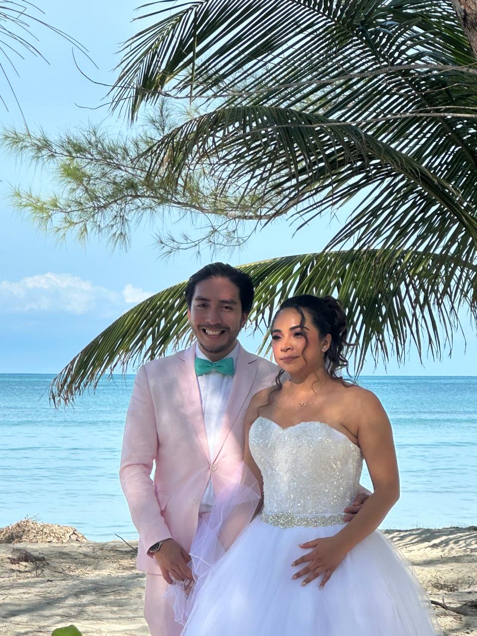 Pareja de recién casados bajo una palmera